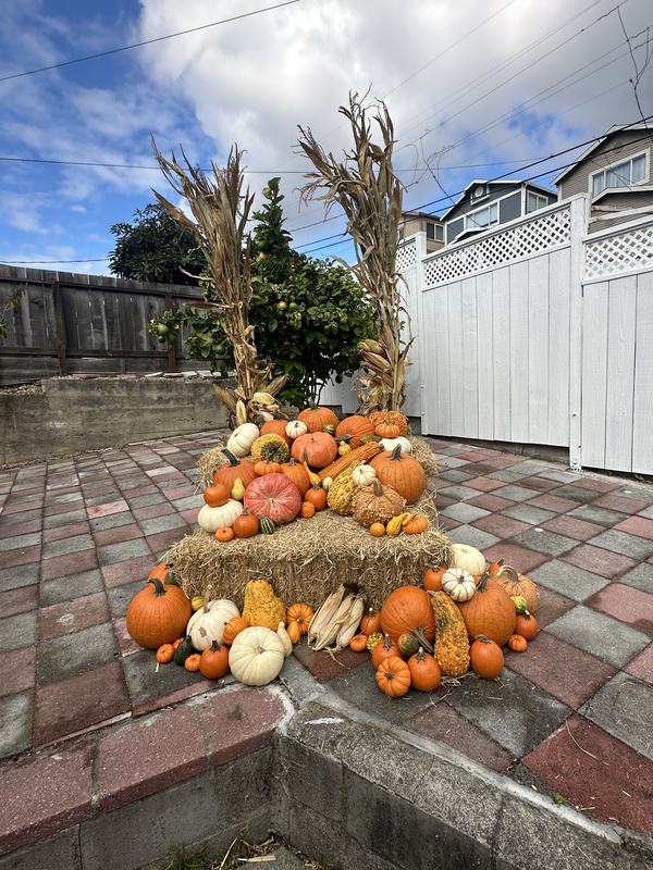Stacked hay bale display topped with pumpkins and gourds